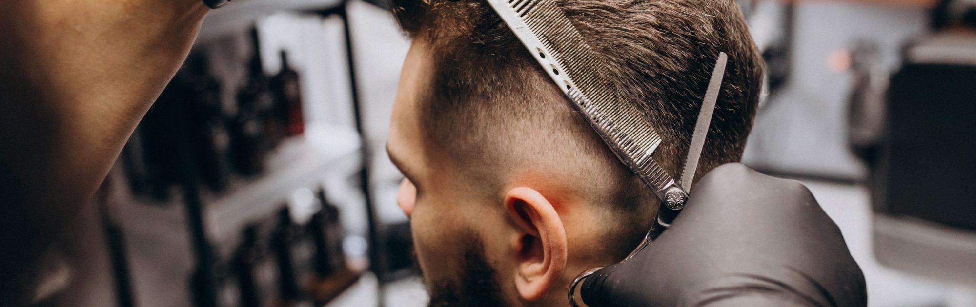 Client doing hair cut at a barber shop salon